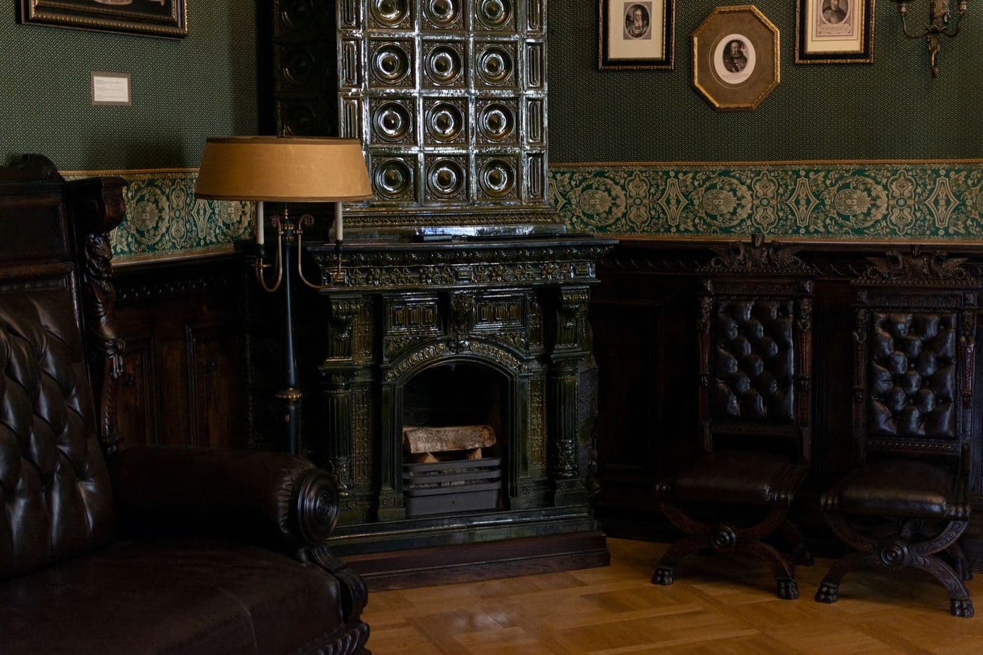 Classic room with a vintage tiled stove and leather furniture, exuding warmth and elegance.